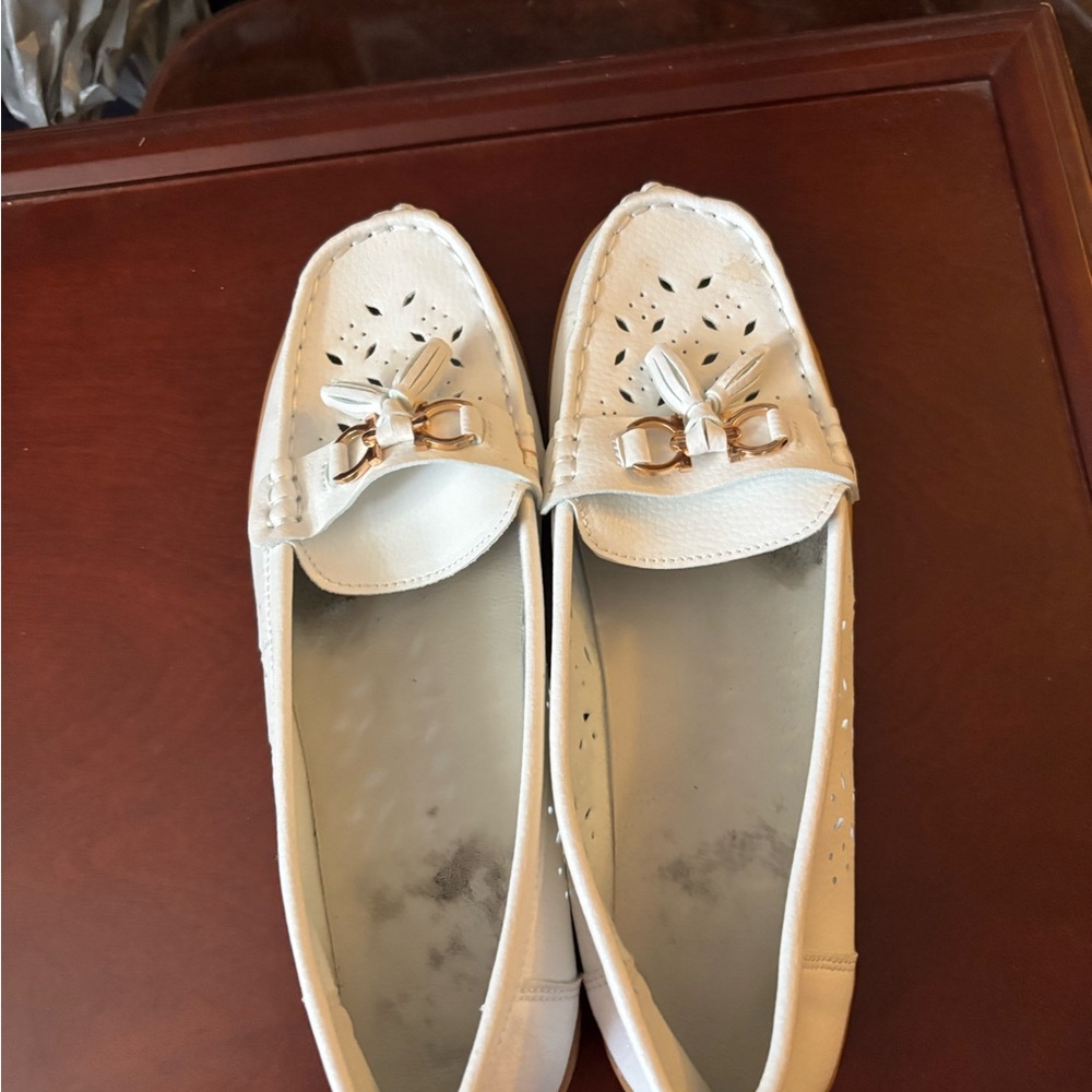 Elegant  white loafers with gold buckle and tassel.